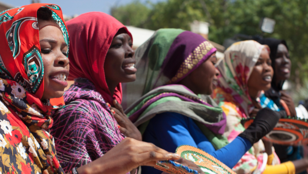 Western Sudan Community Museums project © Yoohoo Media. A group of women in colourful clothing holding traditional Sudanese woven products.