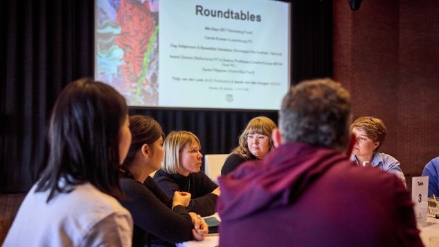 A group of people in discussion around a table.