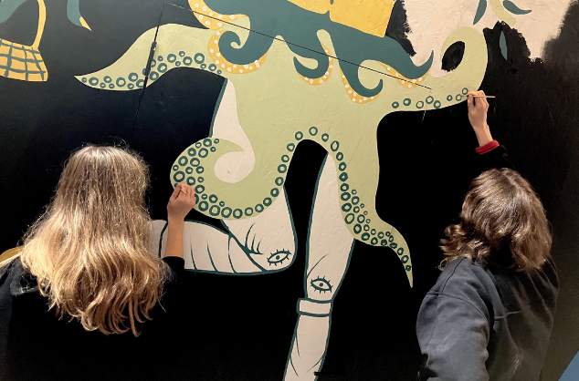Two children work on a mural