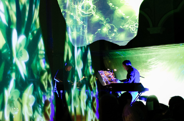 A performance with projections and two musicians