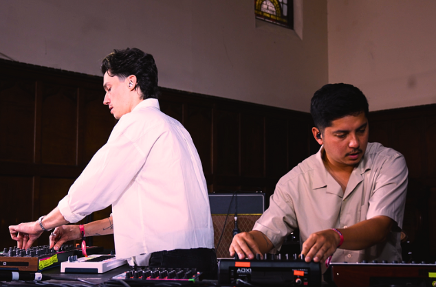 Two men with their hands on mixing decks.