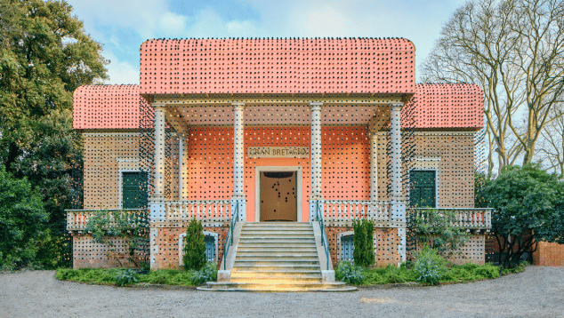Portico of the British Pavilion at the Venice Architecture Biennale 2025. The facade of the Pavilion has been covered in black and orange beads made by Massai women