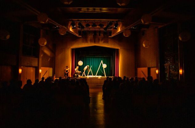 A view from the back of a theatre with a performance in progress