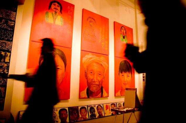 Shadows of people move past painted portrait panels on the wall