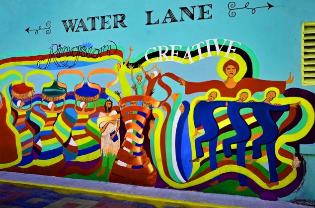A colourful mural featuring people dancing and carrying baskets