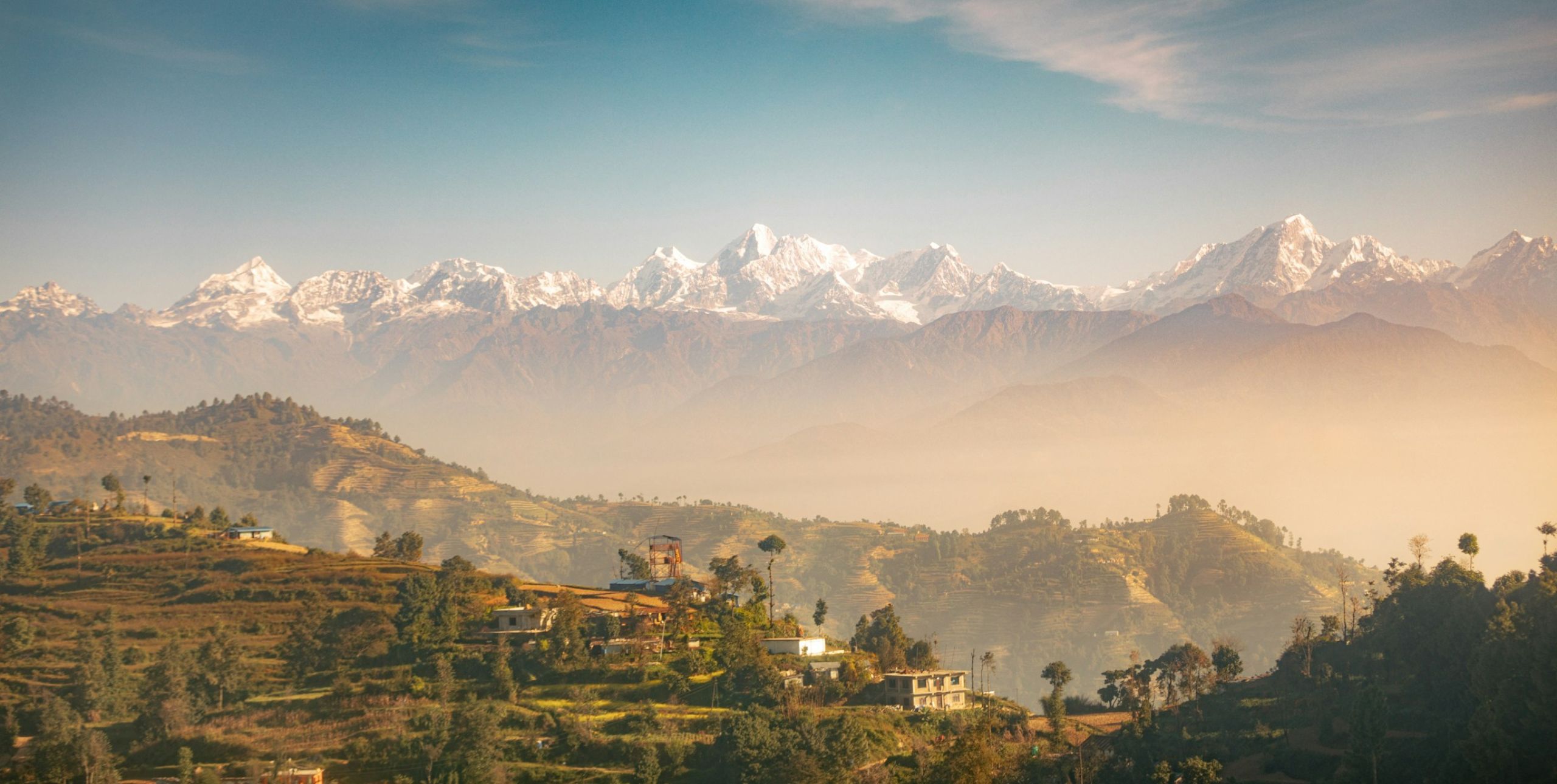 A landscape with snow-capped mountains visible and grasslands in the foreground