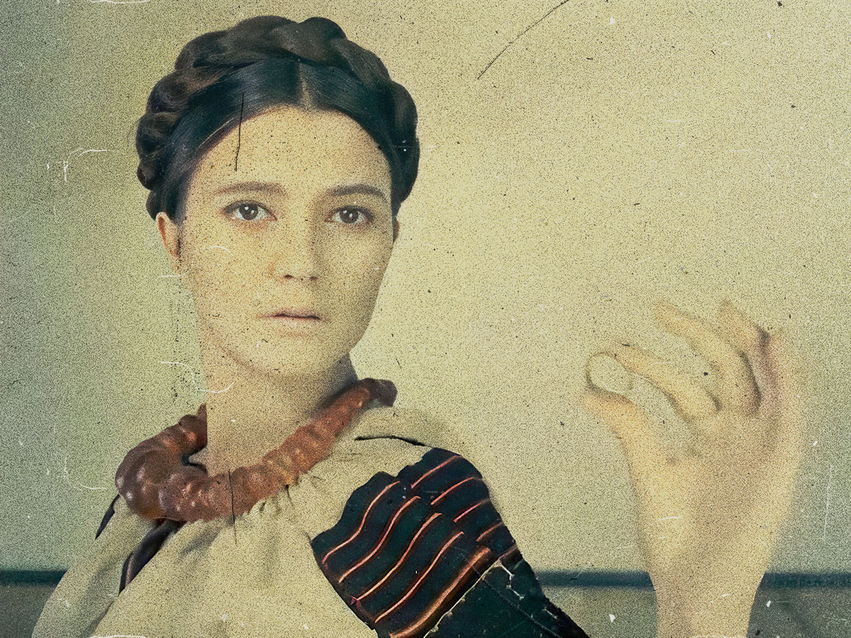 A woman in traditional Ukrainian clothes holds a ring between her fingers and stares into ahead