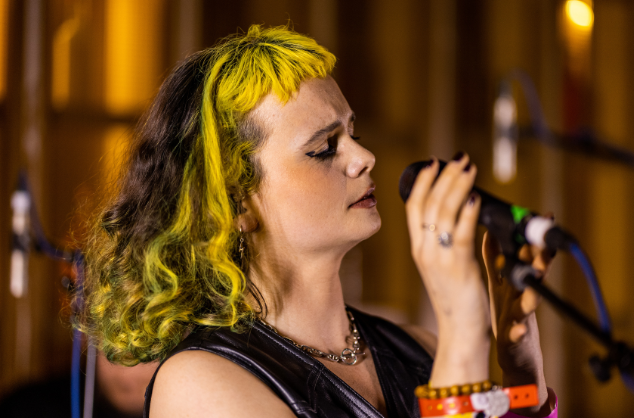 Lady on stage, eyes closed, holding microphone.