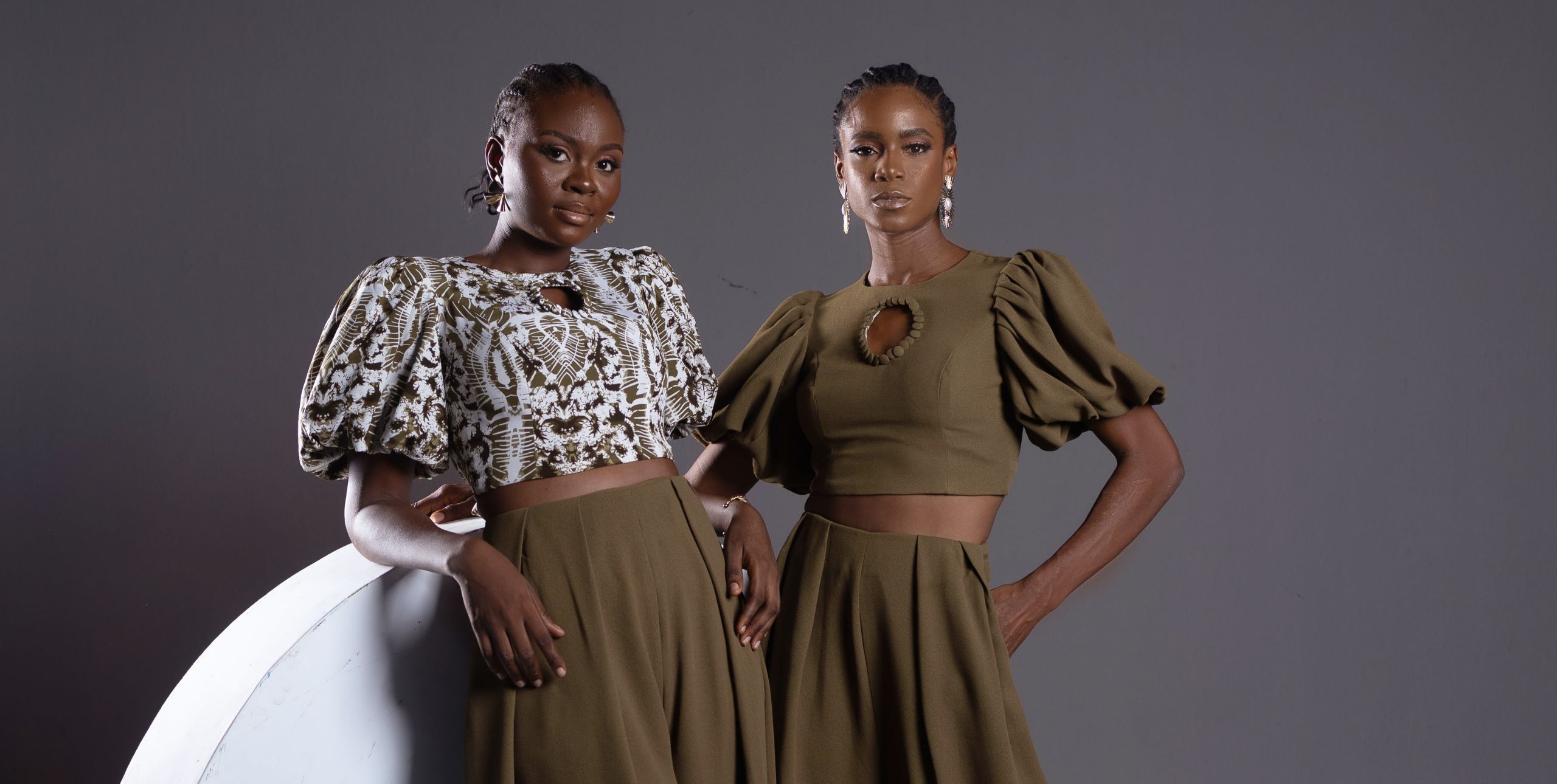 Two models pose in voluminous blouses and skirts