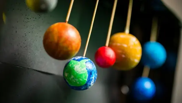 Toy planets hanging down on sticks.