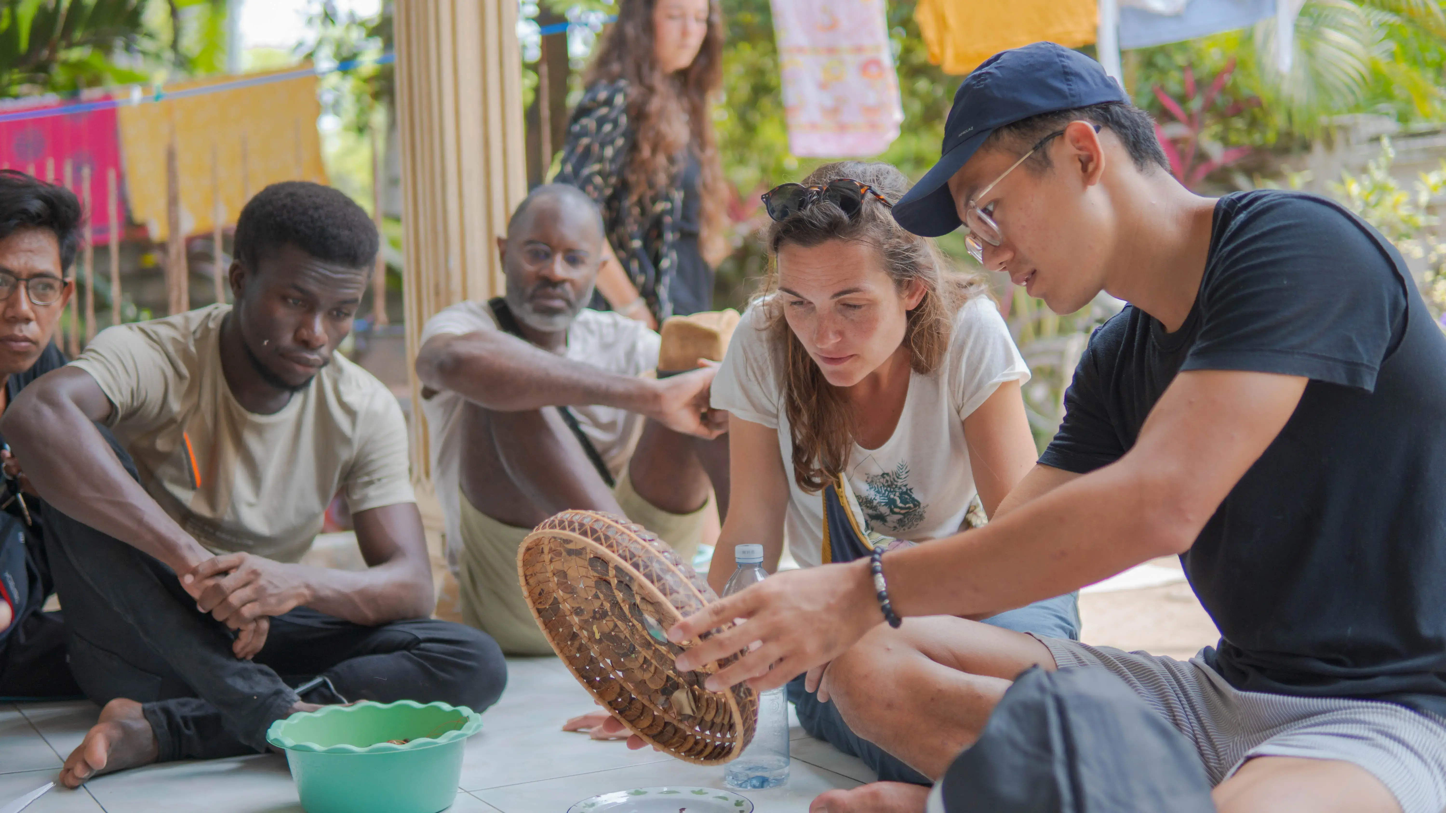 Four people study a handwoven basket as part of the Seeking Generative Tourism project in Malaysia funded by CTC grants