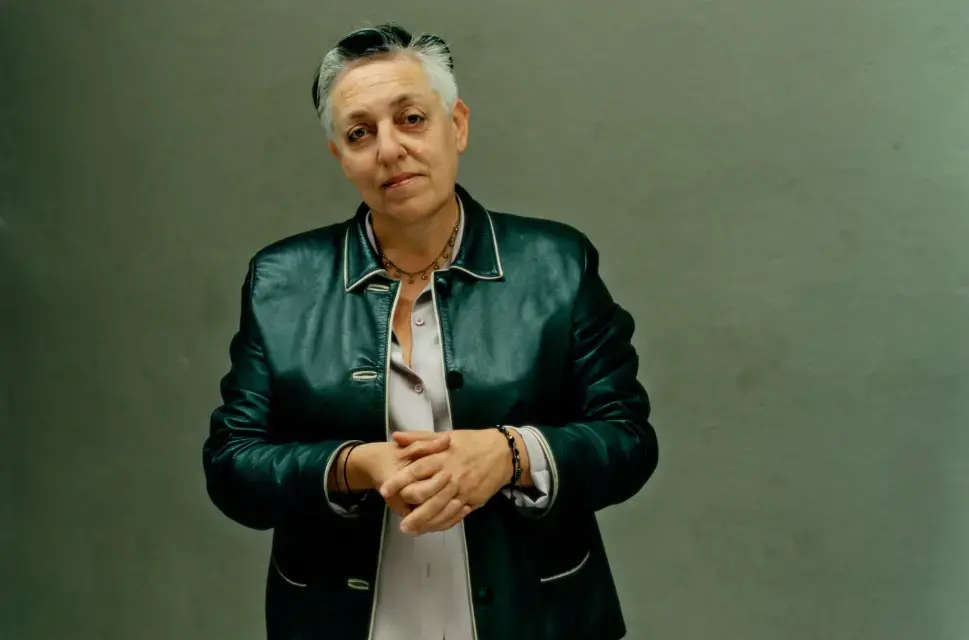 A portrait of Ruth Mackenzie. Ruth has short grey and black hair and wears a leather blazer over a pale grey shirt. Photo by Emma Hardy (c) National Portrait Gallery, London
