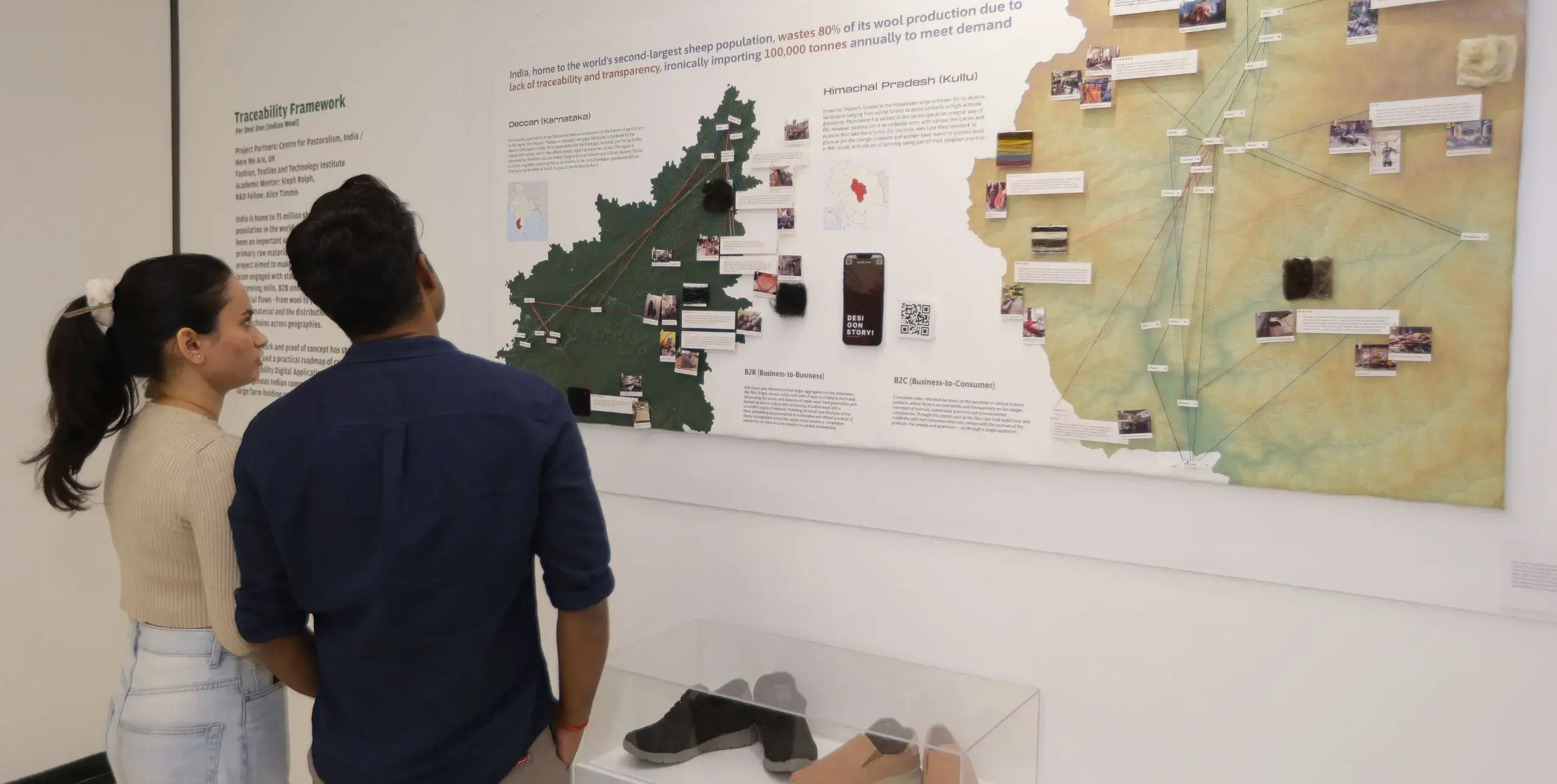 Two people look at a map of India in the exhibition