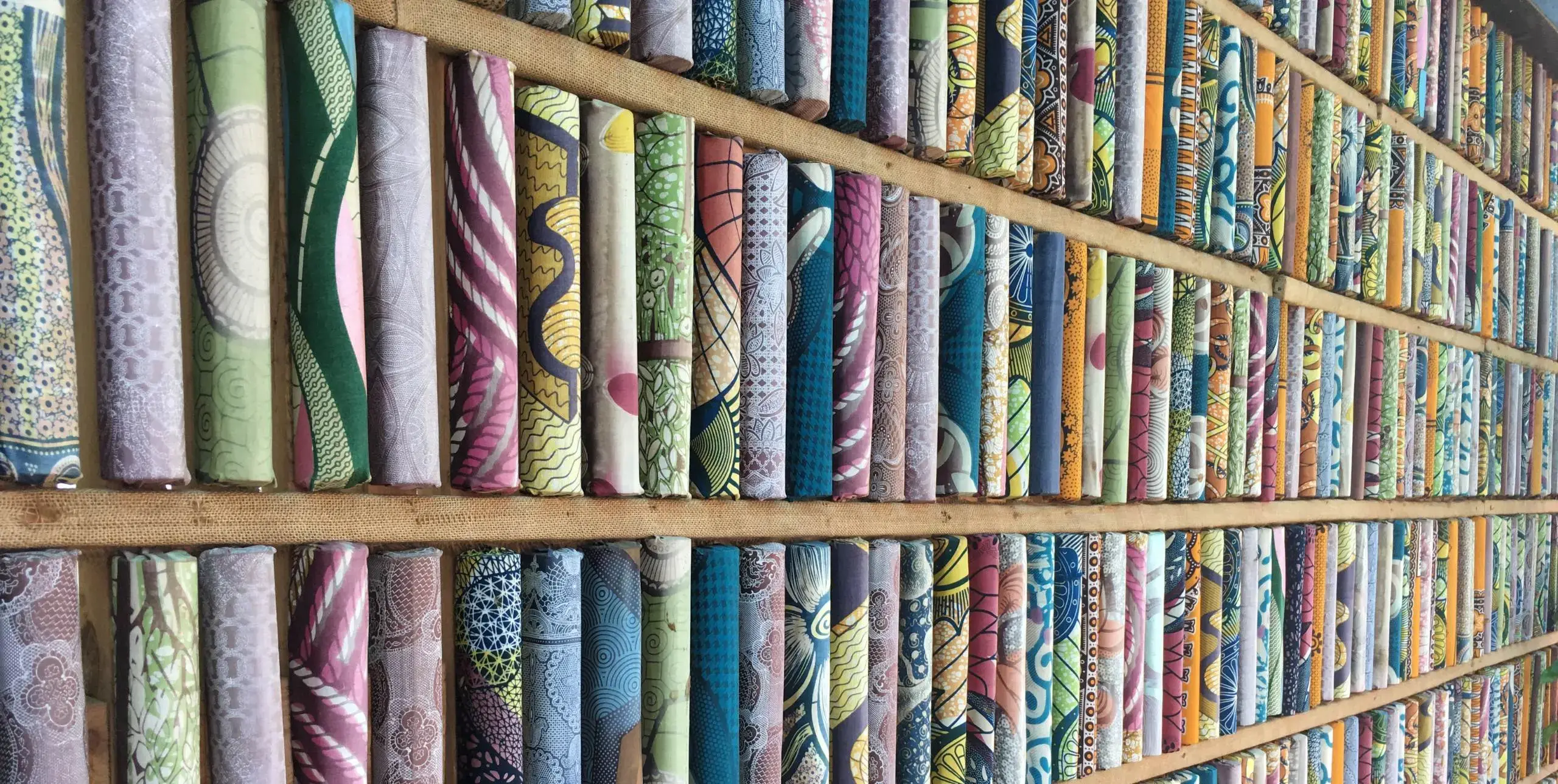 A long bookcase in Kigali public library shows books bound in colourful geometric patterns.