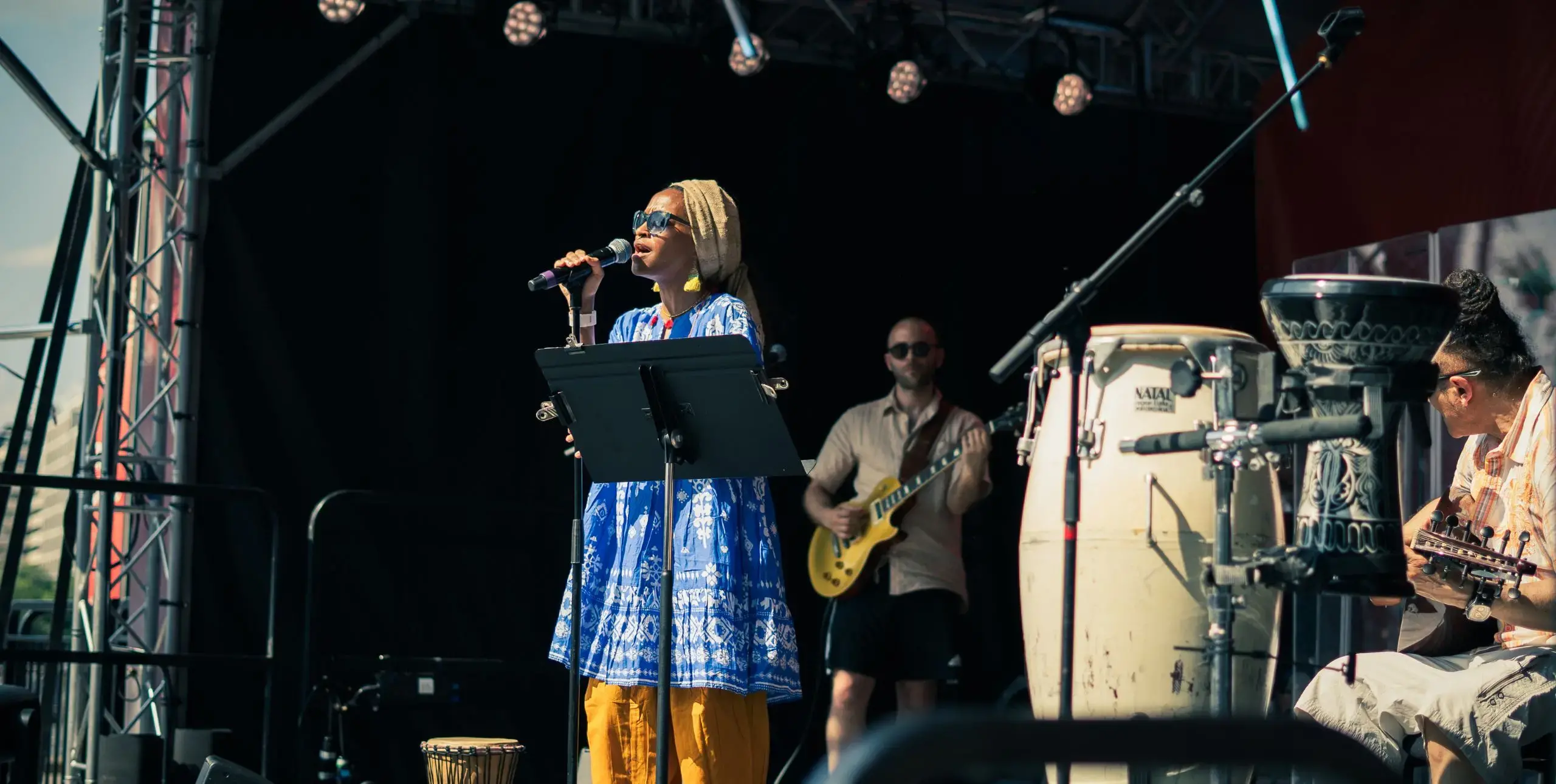 A singer and musicians perform on a festival stage