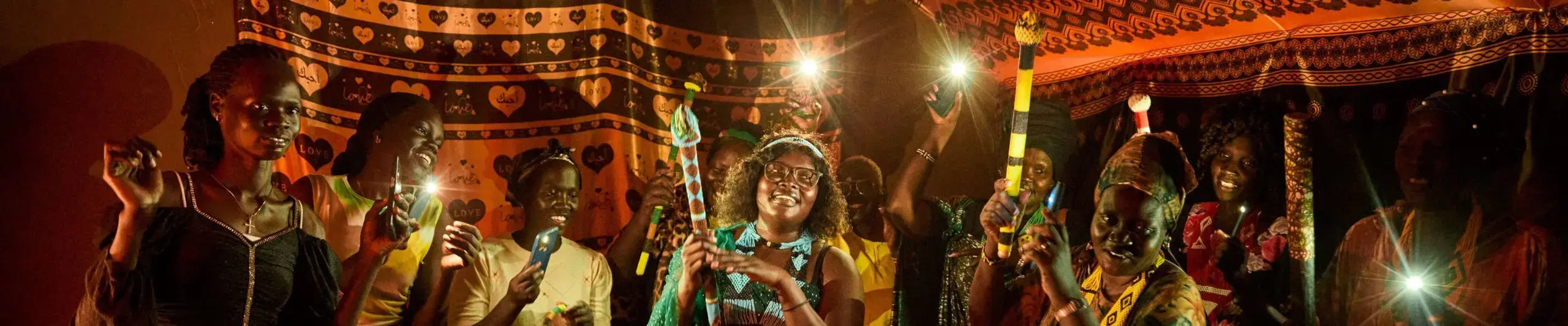 A group of Sudanese women carry candles and dance