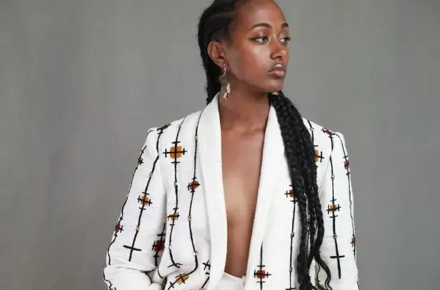 A woman models an embroidered blazer