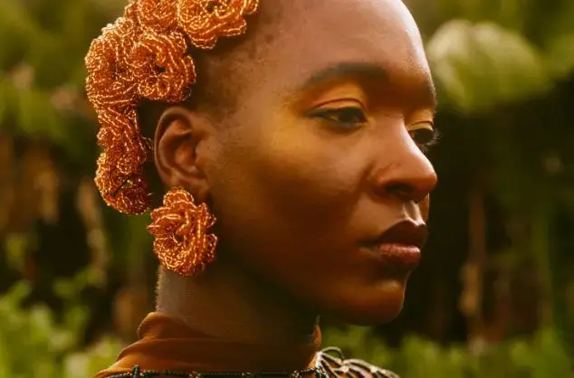 headshot of a woman wearing intricately beaded jewellery
