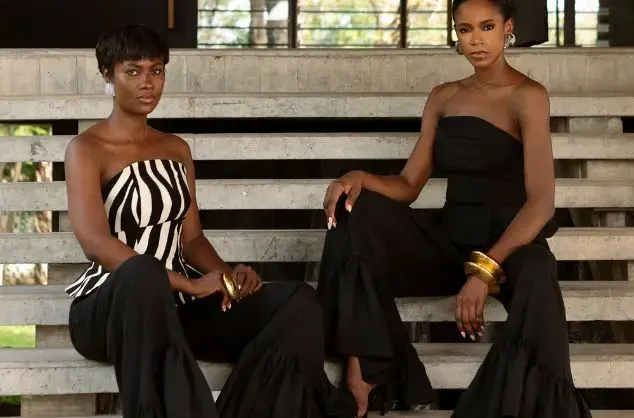 Two women model wide-legged black trousers and bustiers