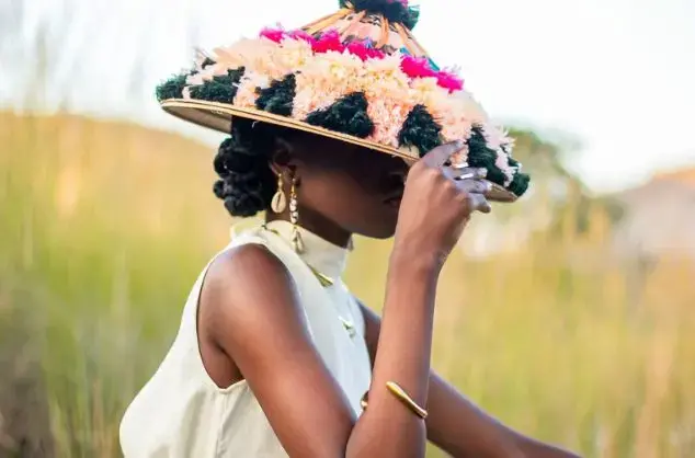 A woman wears an ornately feathered hat