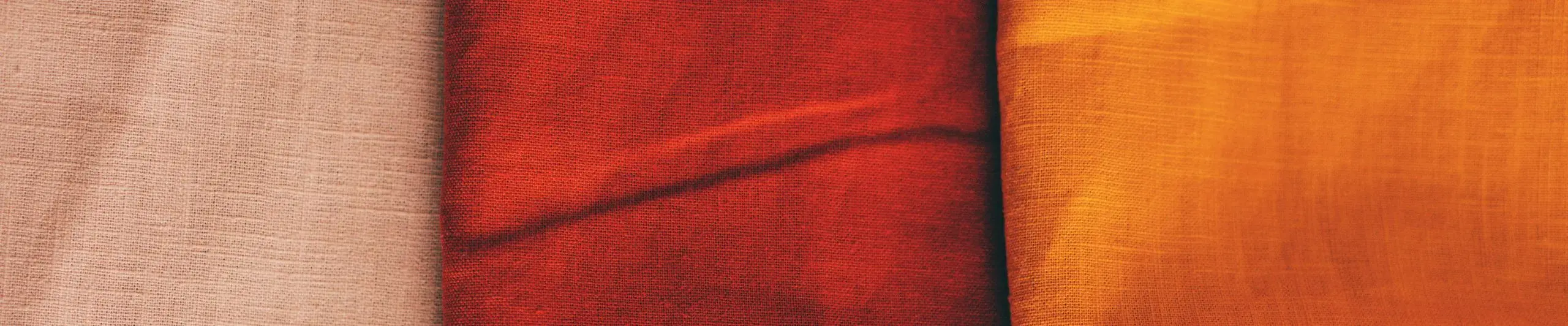 Rolls of dyed linen cloth in pink, red and orange