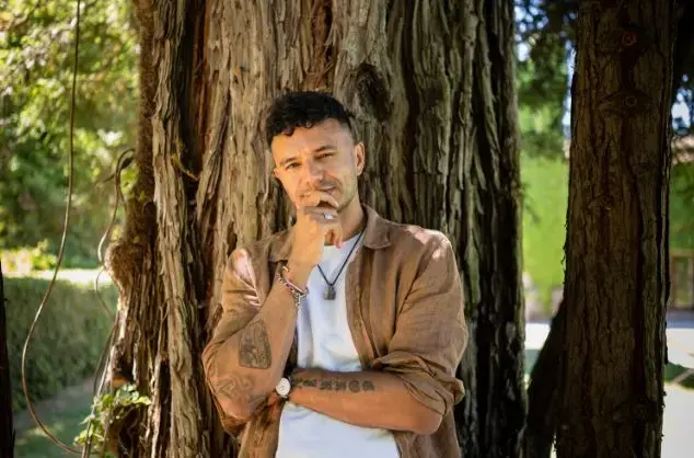 Raymond Antrobus standing in front of a tree
