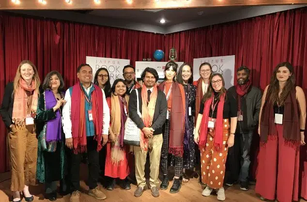 A diverse group of delegates smile at the camera