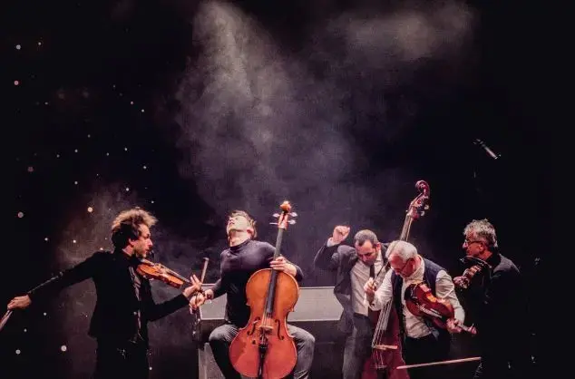 Musicians with stringed instruments give an energetic performance