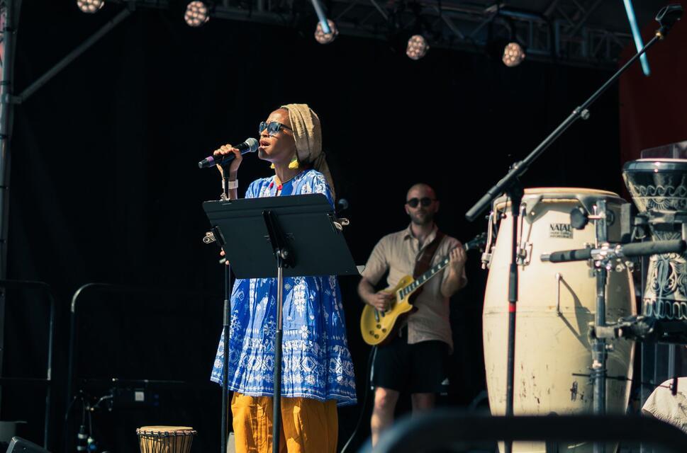 A singer and musicians perform on a festival stage